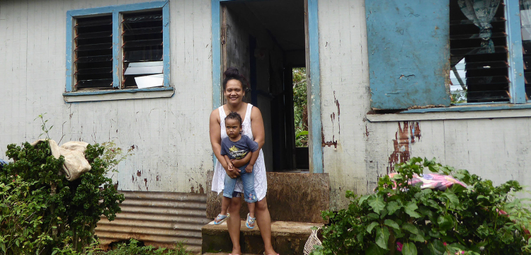 Mother and child by house in Tonga