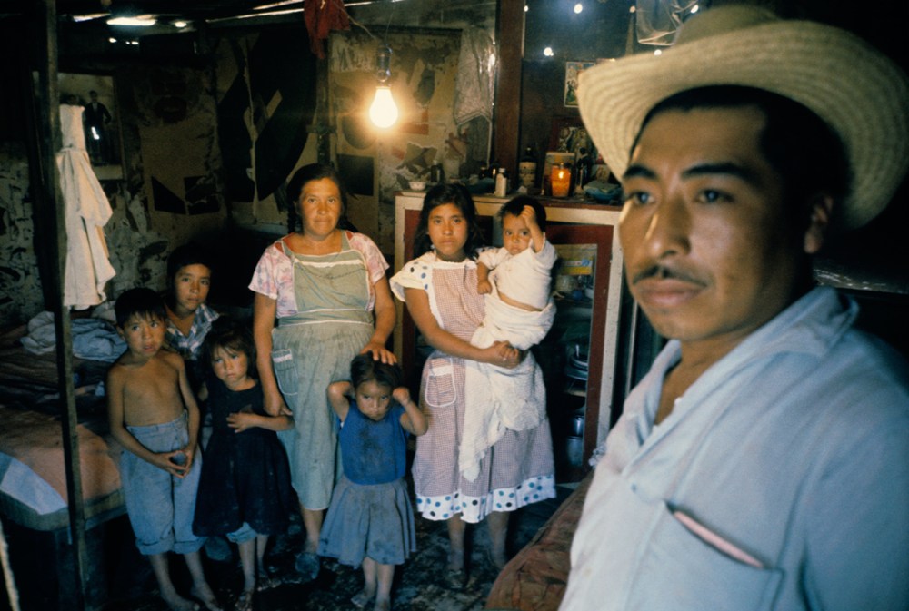 Mexican family: mother, father and 6 children in crowded room.