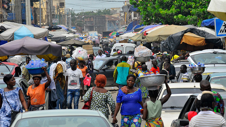 Benin street with people and cars. From http://www.worldbank.org/content/dam/photos/780x439/2017/mar-2/bj-benin-public-consultations-inform-world-bank-groups-systematic-country-diagnostic-economic-780x439.jpg