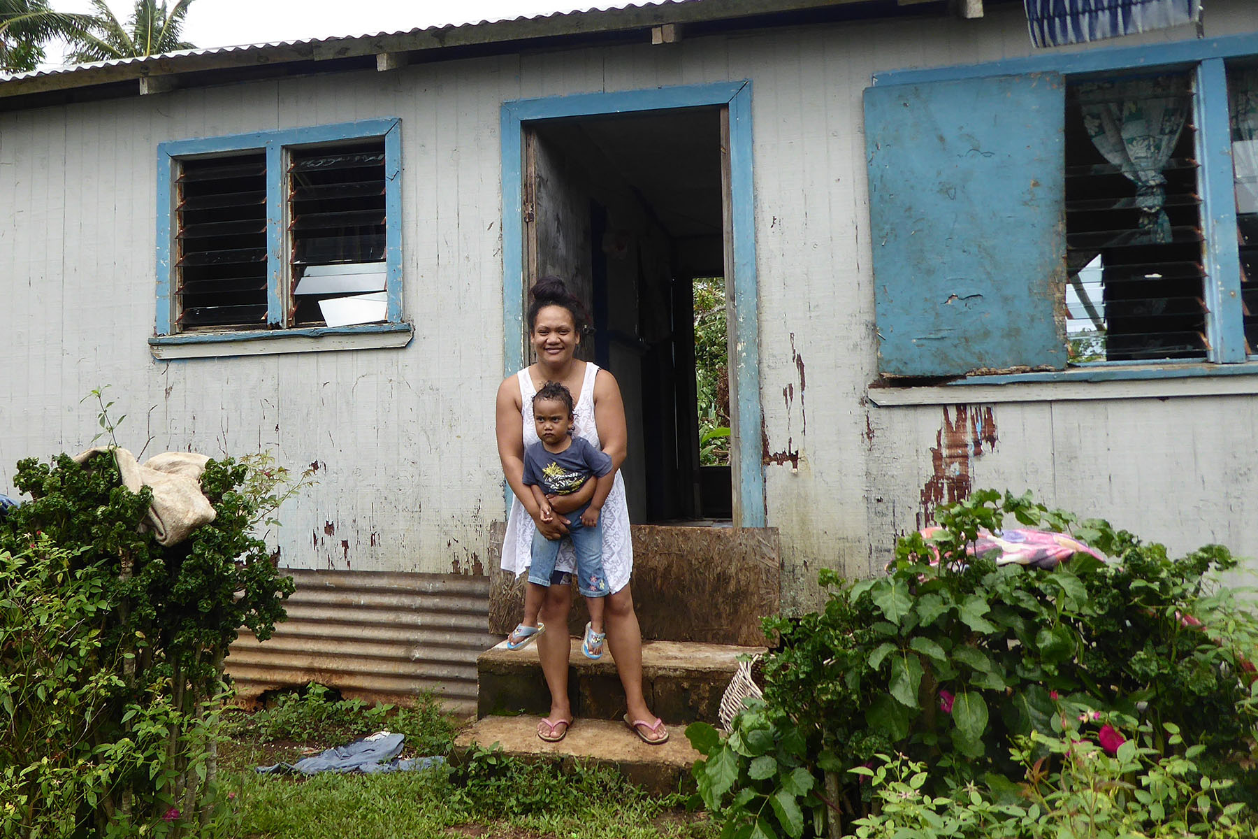 Mother and child by house in Tonga