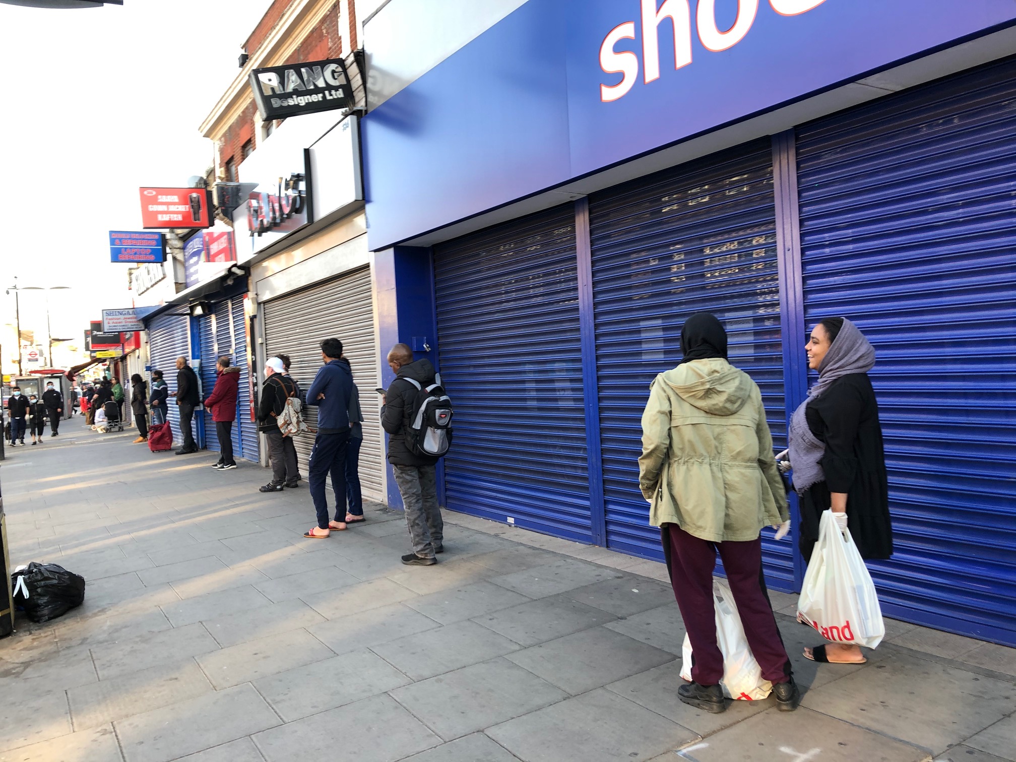 queue outside supermarket observing social distancing, East London 