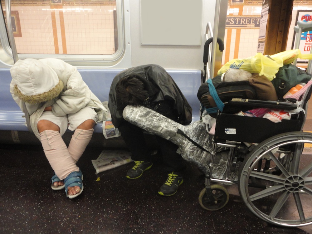 Two homeless people sleeping on New York subway. 