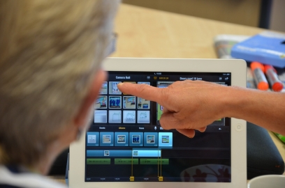 a hand pointing at a picture on an iPad