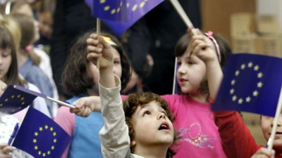 Children waving small EU flags