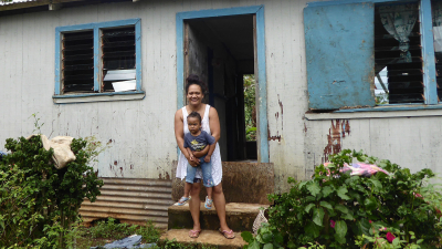 Mother and child by house in Tonga